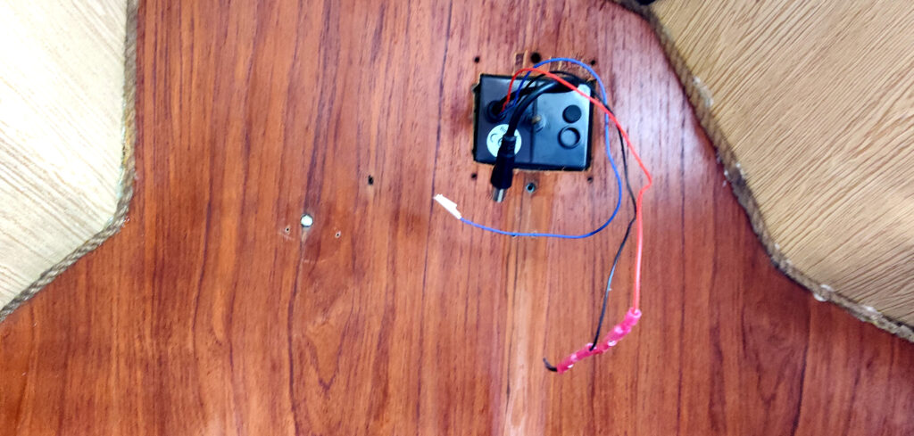 Mahonkinen laipio, jossa kiinni näyttö, josta roikkuu irrotettuja johtoja. Elektroniikka-asennus ei ala ennen vanhojen purkamista. 