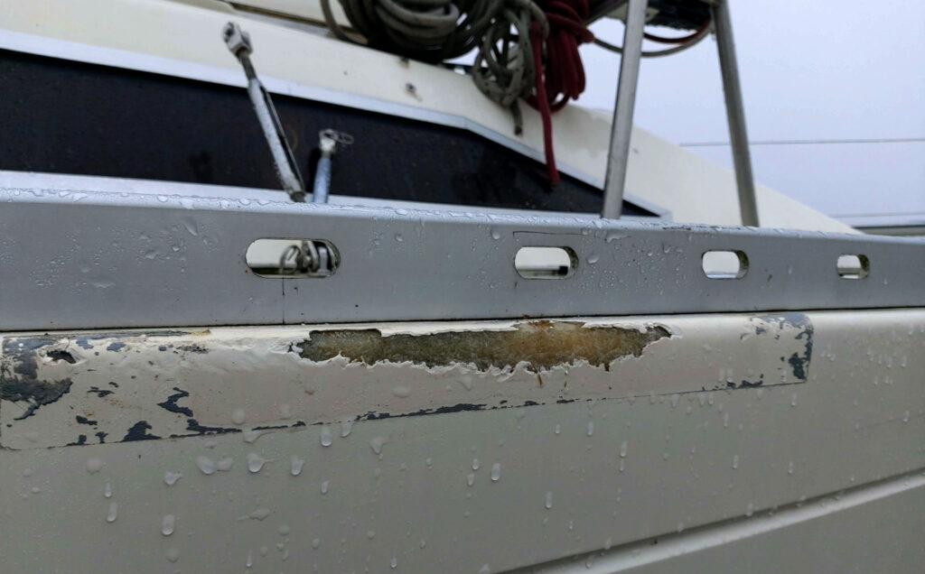 Veneen kylki, jossa näkyy lasikuitu vaurion seurauksena.