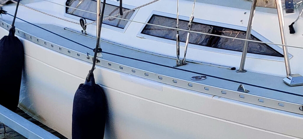 Veneen kylki, jossa valkoinen teippipaikkaus