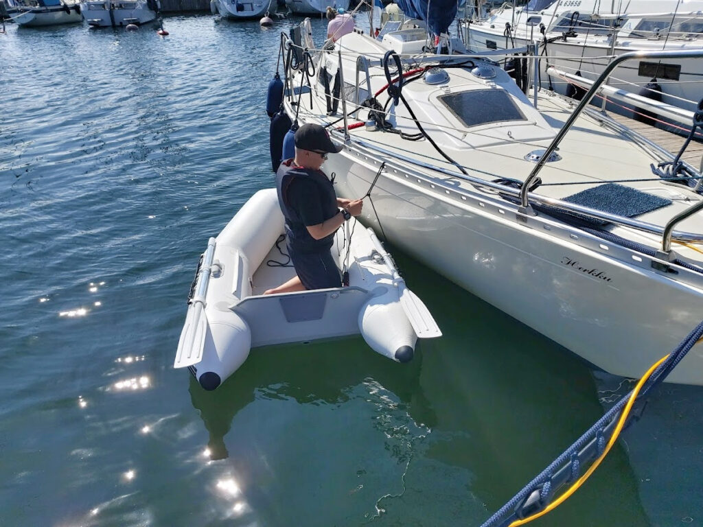 Lapsi kumiveneessä purjeveneen vieressä, Moottorin sähköongelma ratkeaa, 