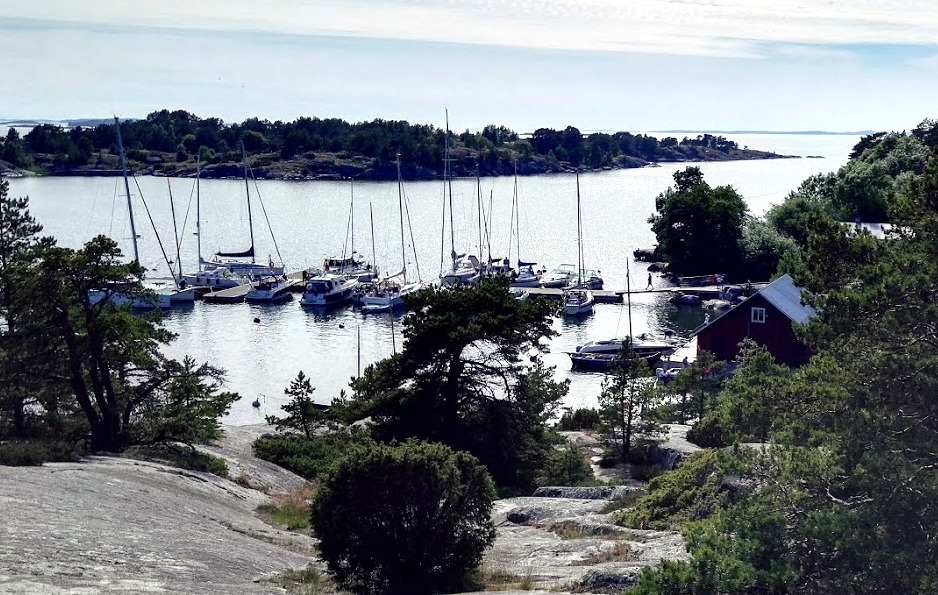 Satama kuvattuna korkealta kalliolta, laituri täynnä purjeveneitä.