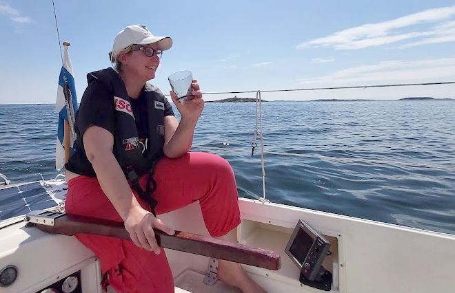 Nainen veneen pinnassa lasi kädessä