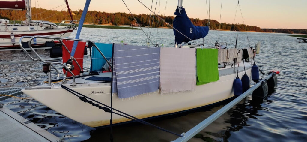 Veneen kaiteissa kuivumassa pyyhkeet ja uimapuvut