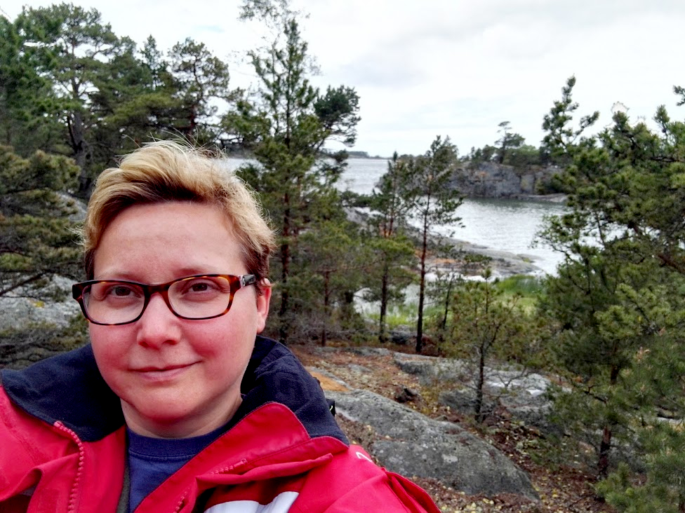 nainen kalliolla, suojaisa lahti taustalla