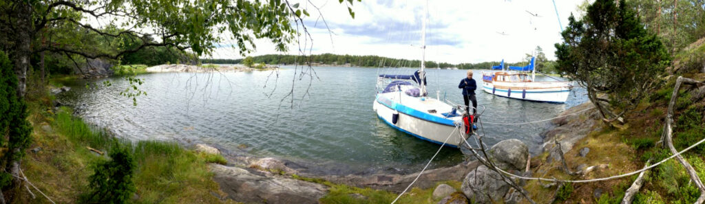 Poika astumassa maihin ankkuroidusta veneestä