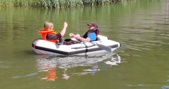 Kaksi lasta valkoisessa kumiveneessä