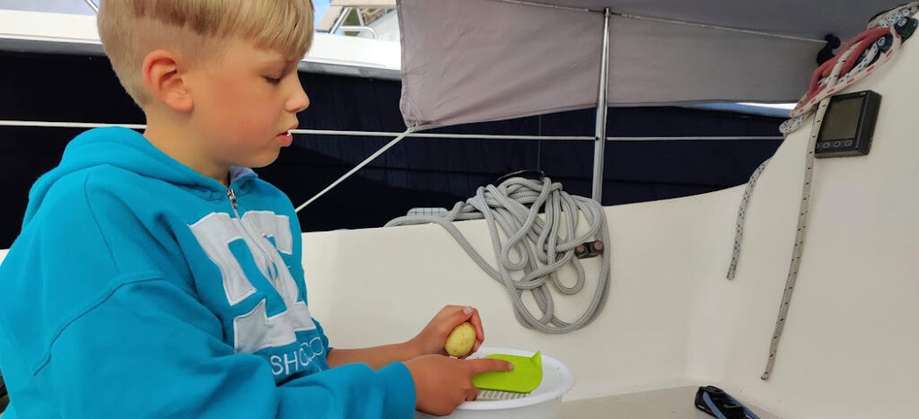 Lapsi pesee perunoita veneellä