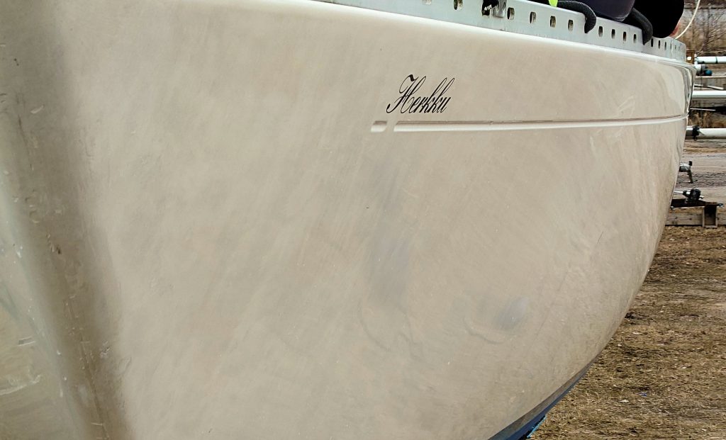 Purjeveneen kylki ennen projektia: veneen kylkien kiillotus.